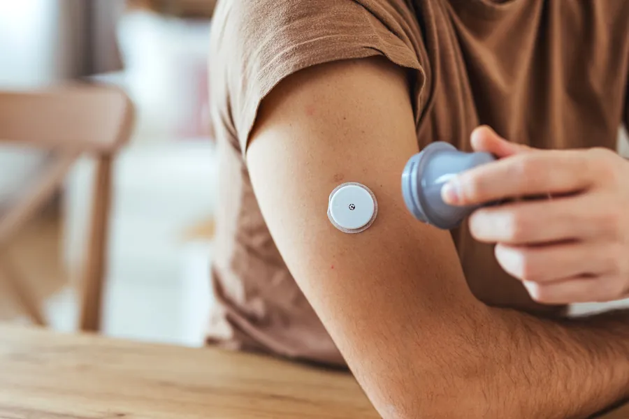 Person checking glucose monitor